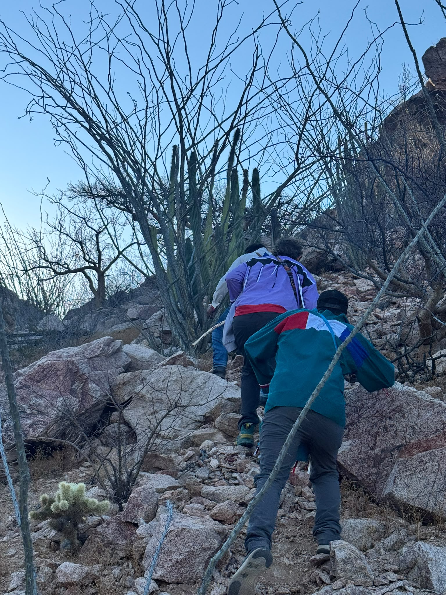 Climbing the rocky desert path up to the ancestral cave at dawn