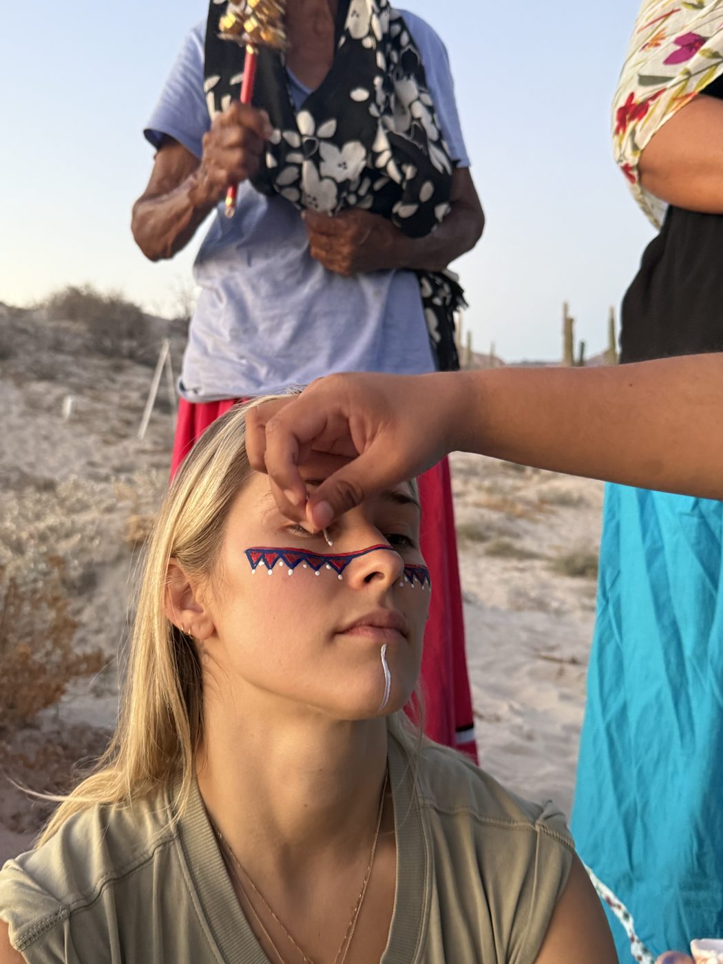 Receiving ceremonial face paint in the desert