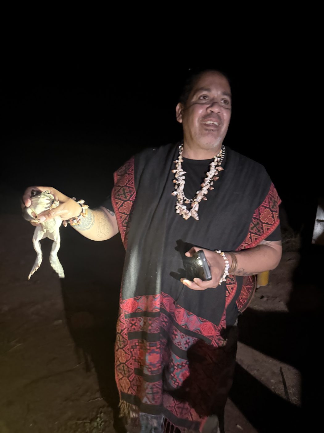 A guardian holding Bufo during a night ceremony